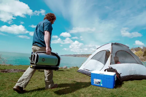 man walking to tent with camping air conditioner.