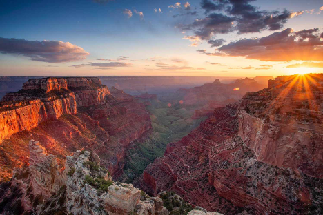 green valley with rocky mountains on both sides at sunrise