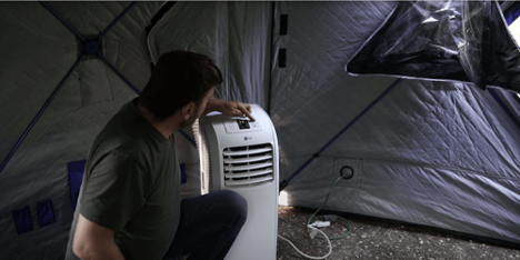 person sitting in tent with air conditioner.