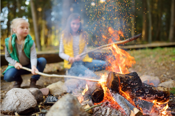 Girls poking a campfire