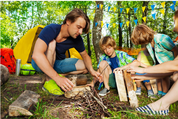 Children building a fire with their father