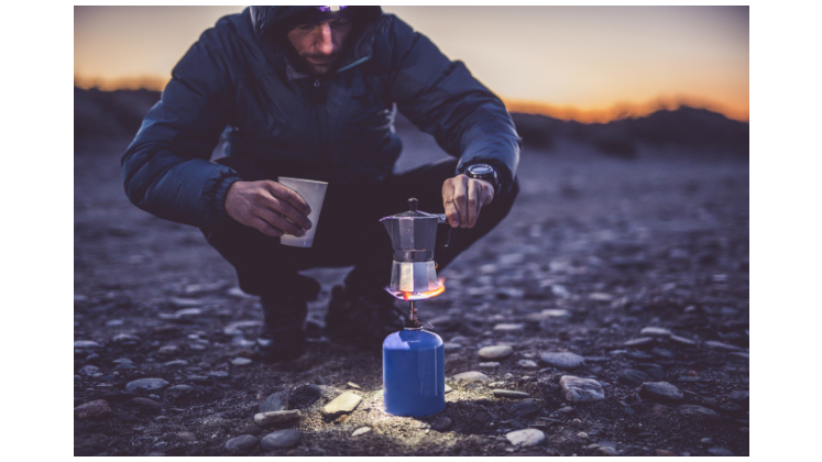 a man brewing coffee in the wilderness