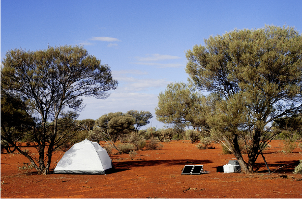 campsite with tent, solar panel and cooler