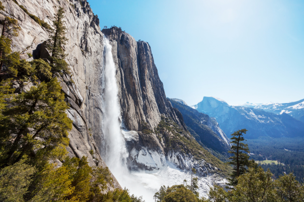 a waterfall coming off of a cliff into a valley