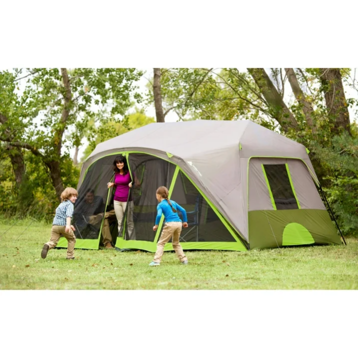 A woman and two kids next to a pop up tent