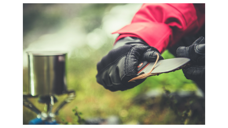 man cutting stick with knife