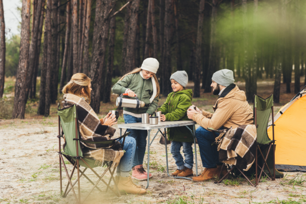 A family sitting around camping table having a drink