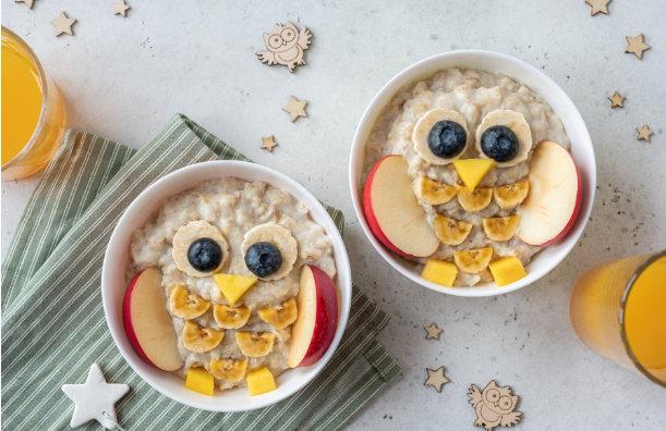 Two bowls of oatmeal with fruit in them