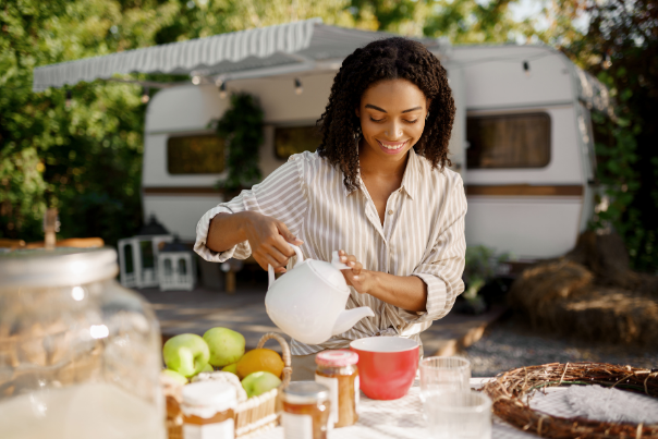 Lady pouring coffee into a mug on a table with breakfast foods