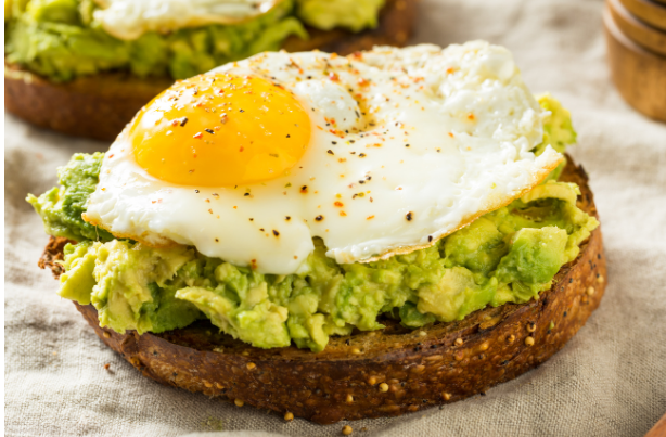 a piece of toast with avocado and an egg on it