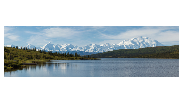 a lake in between to hills with a mountain in the background