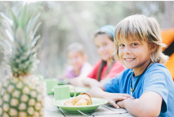 Kids sitting at a table eating breakfast