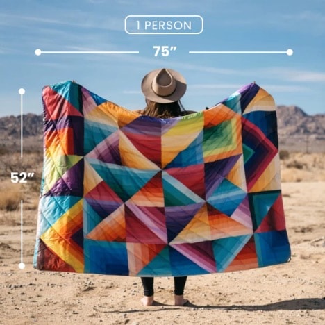 A person holding a blanket in the desert